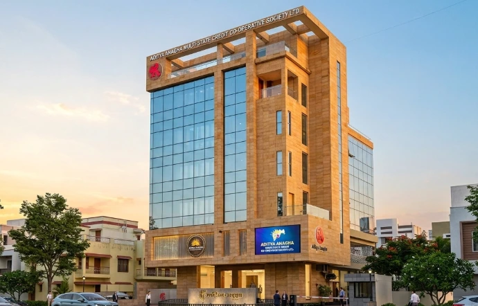 Featuring a sophisticated contemporary facade, this high-rise commercial structure combines expansive blue-reflective glass curtain walls with warm, textured sandstone-finish cladding. The design balances bold geometric framing and open terrace balconies on the upper levels with clean, integrated ground-floor retail access and high-visibility digital signage, creating a striking modern landmark in the urban landscape.